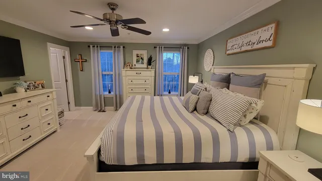 a bedroom with a large bed a flat tv screen and dresser