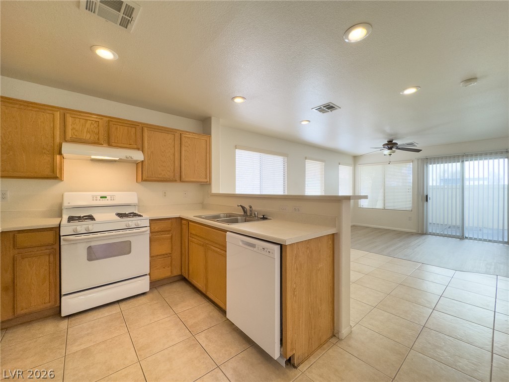 9456 Grandview Spring Avenue Las Vegas, NV 89166 - Photo 16 of 49 A functional kitchen provides ample cabinetry and counter space, with an adjacent bright living area.