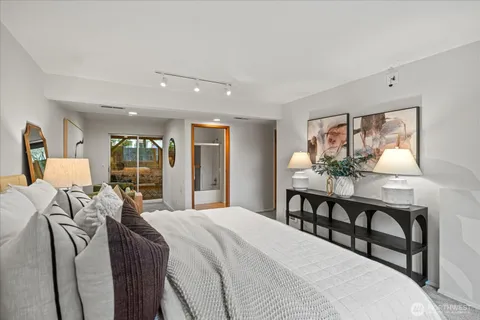 a bedroom with a bed table and chairs