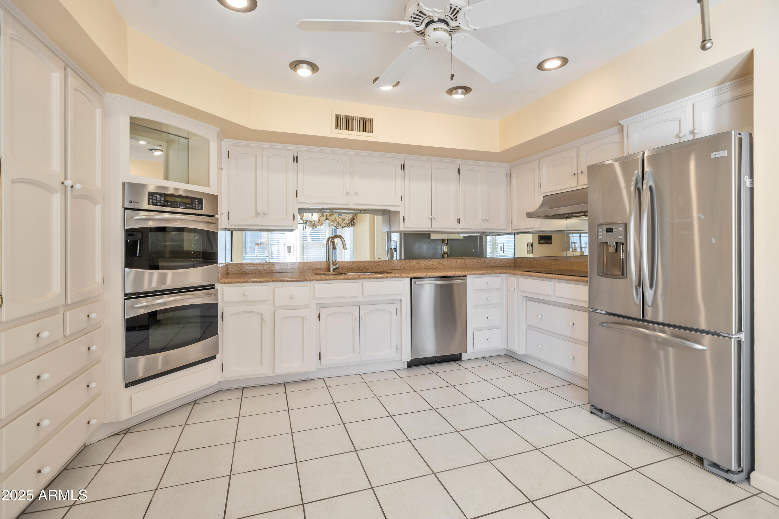 6701 North Scottsdale Road, Unit 23 Scottsdale, AZ 85250 - Photo 22 of 47 a kitchen with white cabinets stainless steel appliances and a window