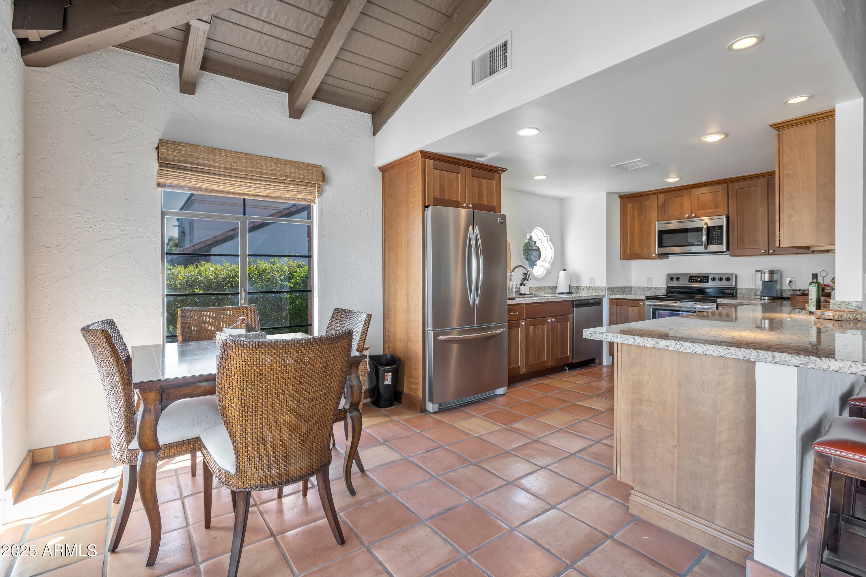 6701 North Scottsdale Road, Unit 23 Scottsdale, AZ 85250 - Photo 43 of 47 a kitchen with stainless steel appliances granite countertop a dining table chairs refrigerator and microwave