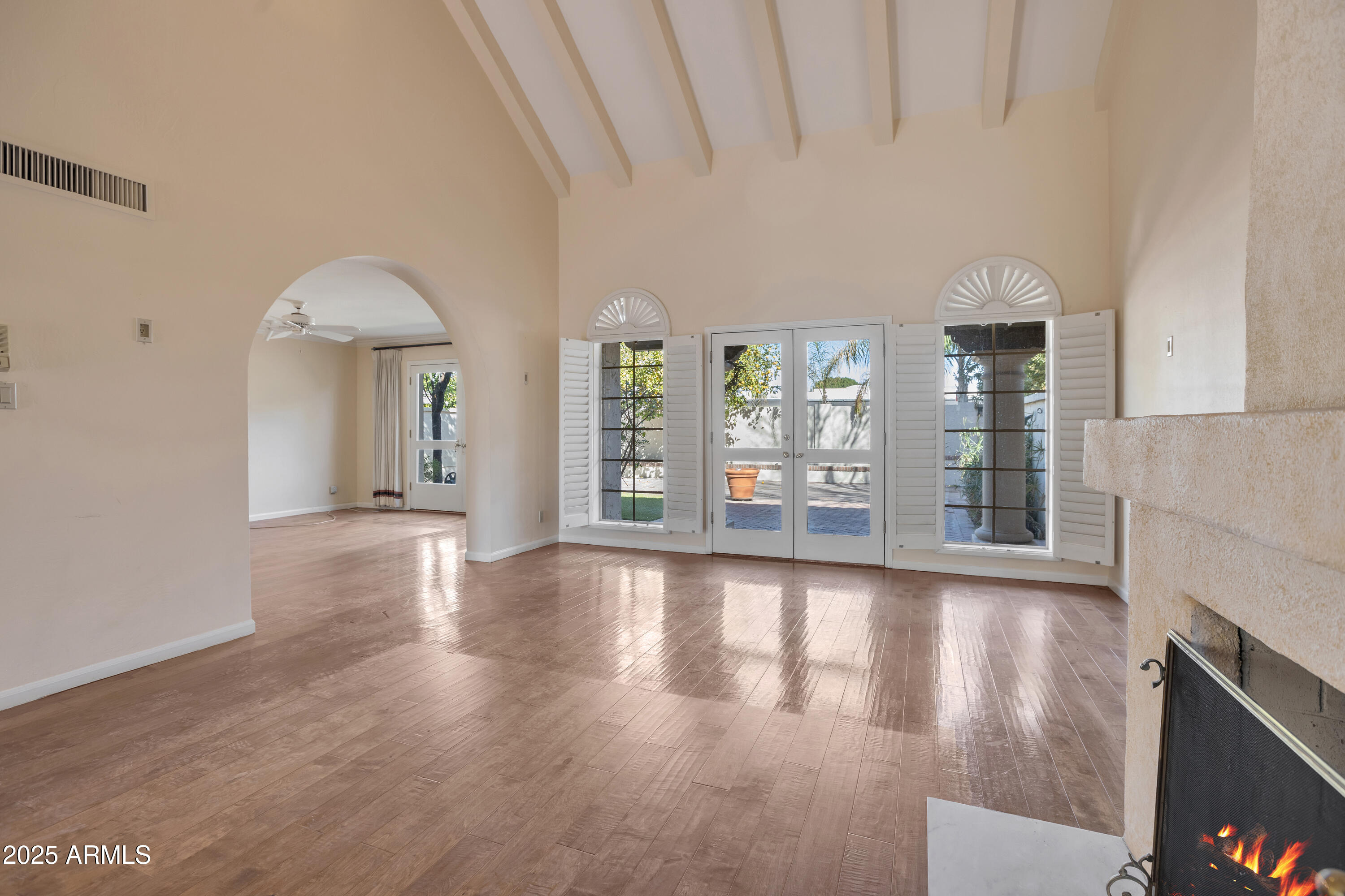6701 North Scottsdale Road, Unit 23 Scottsdale, AZ 85250 - Photo 9 of 47 a view of an empty room with wooden floor and a fireplace