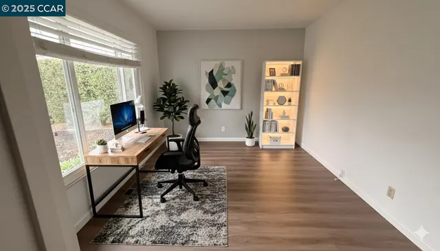 a view of a workspace with wooden floor and a window