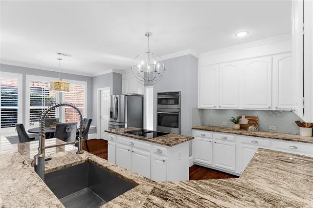 a kitchen with granite countertop a stove and cabinets