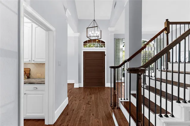 a view of a hallway with wooden floor and staircase