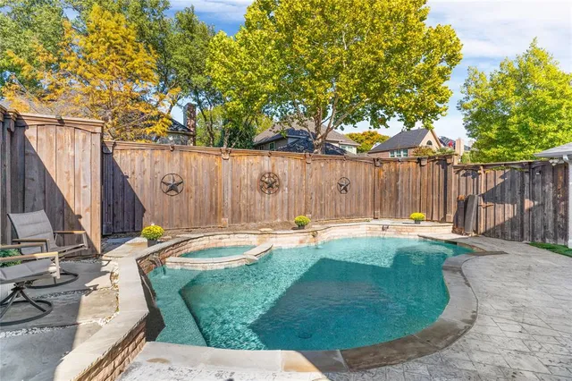a backyard with swimming pool and wooden fence
