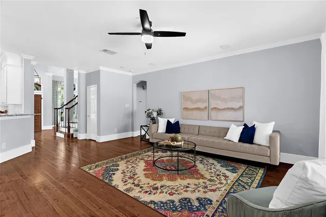 a living room with furniture and a wooden floor