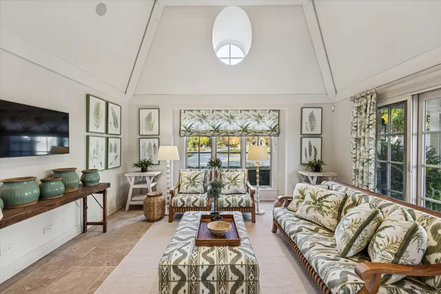 an aerial view of a house with swimming pool and large trees