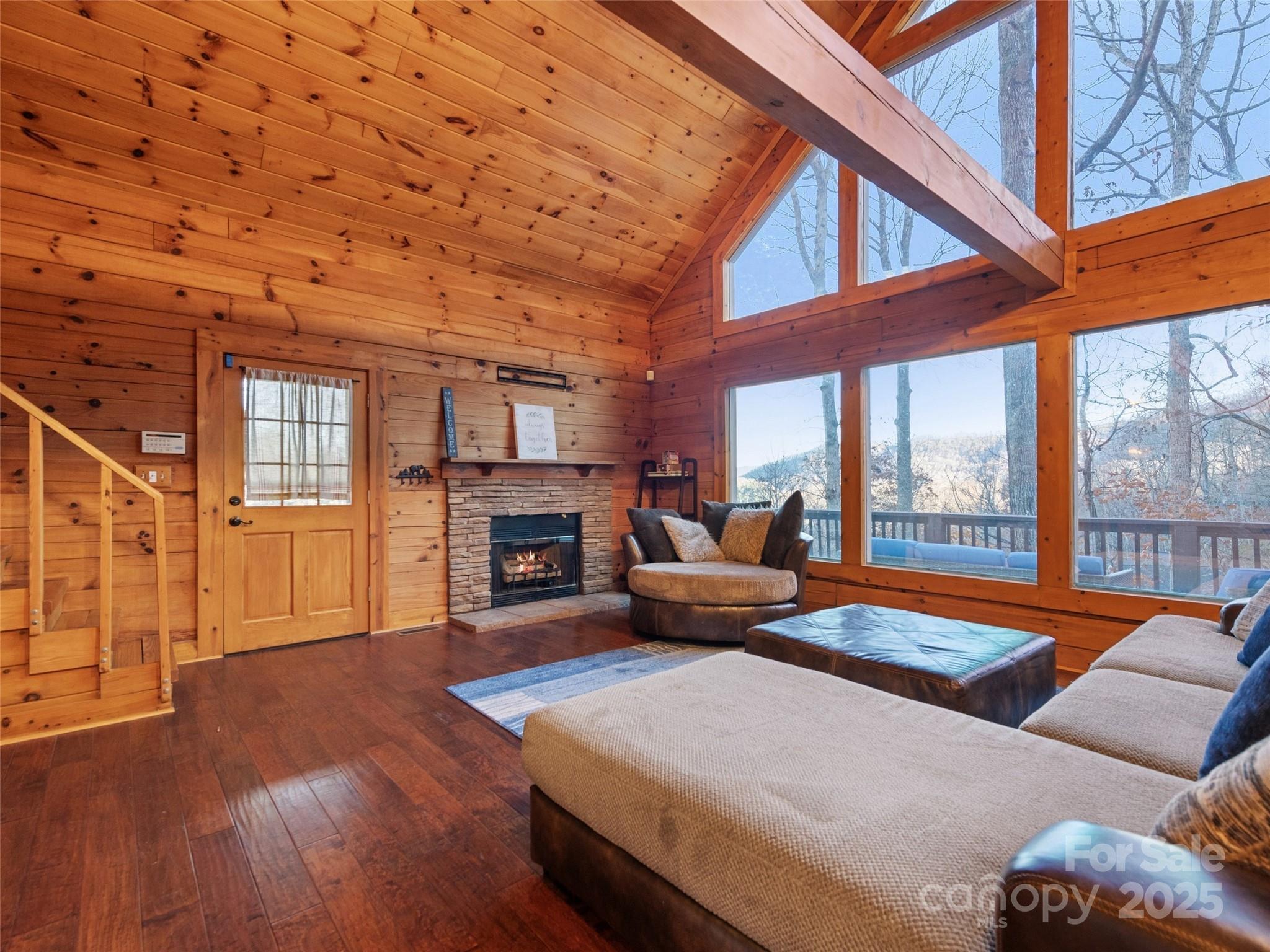 36 Wonder View Point Waynesville, NC 28785 - Photo 11 of 40 a living room with furniture a fireplace and a floor to ceiling window