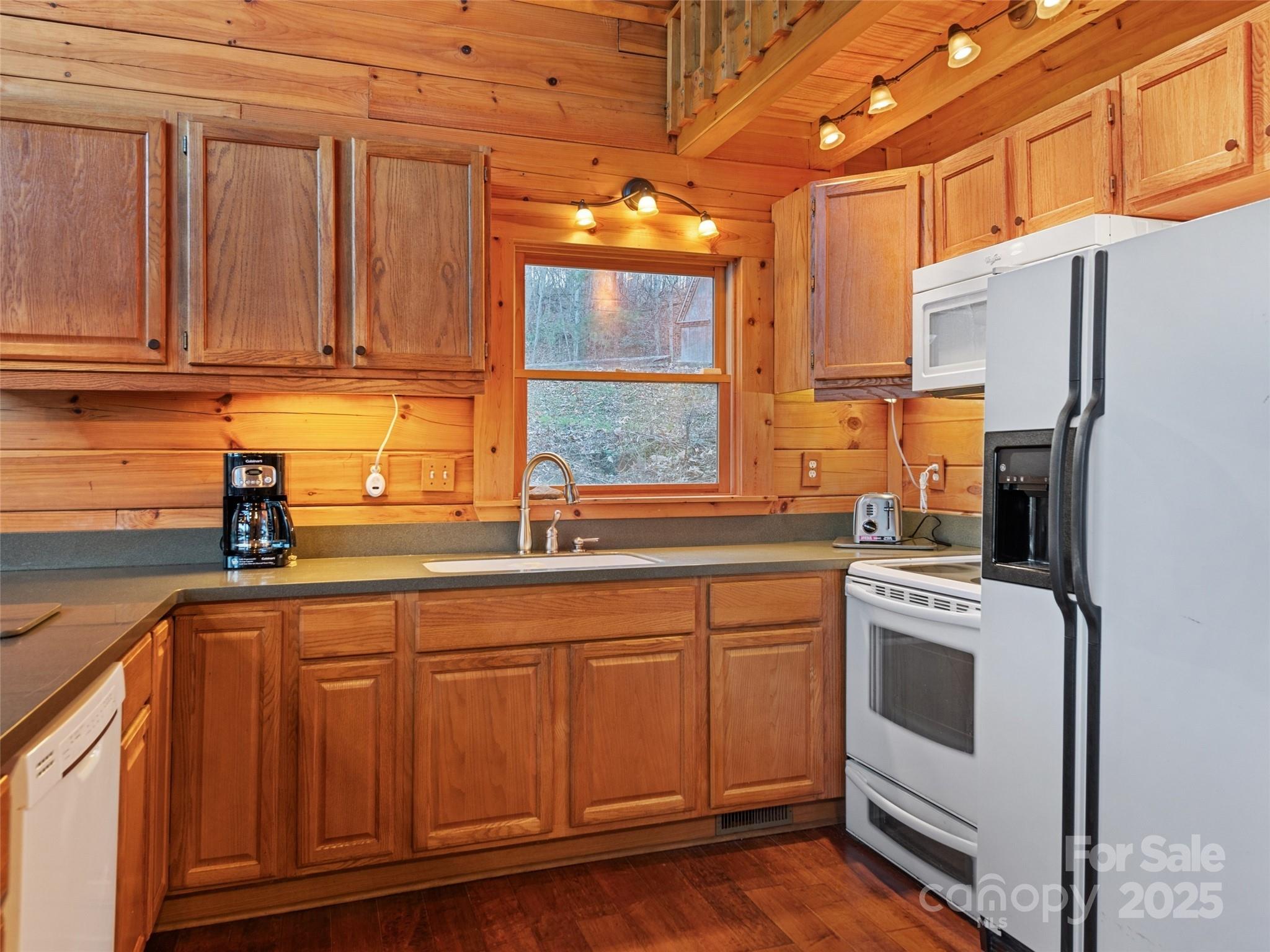 36 Wonder View Point Waynesville, NC 28785 - Photo 18 of 40 a kitchen with stainless steel appliances granite countertop a refrigerator a sink dishwasher and white cabinets with wooden floor