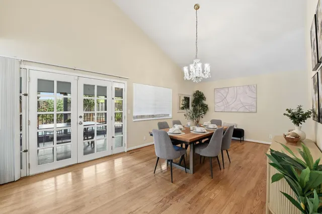 a dining room with furniture a chandelier and wooden floor