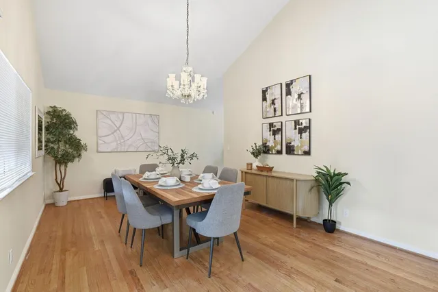 a dining room with furniture a chandelier and wooden floor