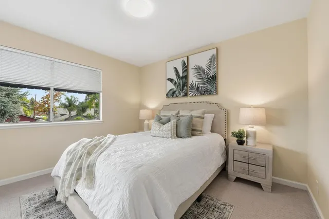 a bedroom with a bed and a large window