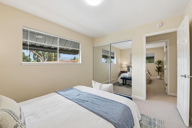 a bedroom with a bed and a large window