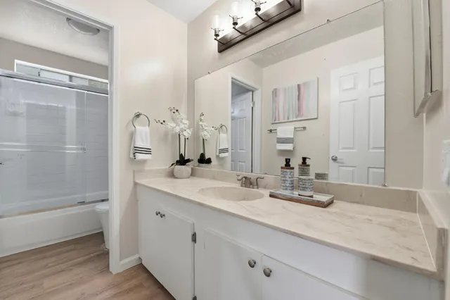 a bathroom with a double vanity sink a mirror and a bathtub