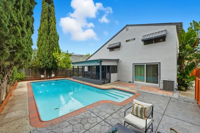 a view of a house with pool and sitting area