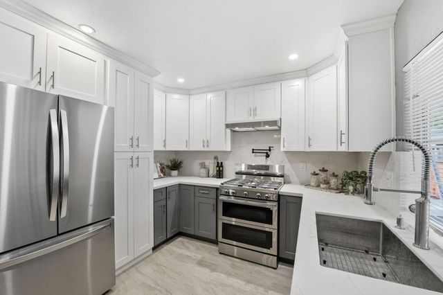 a kitchen with stainless steel appliances a stove sink and refrigerator