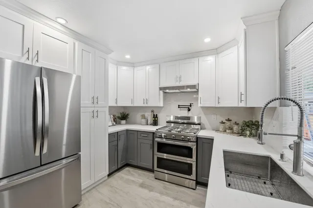 a kitchen with stainless steel appliances a stove sink and refrigerator