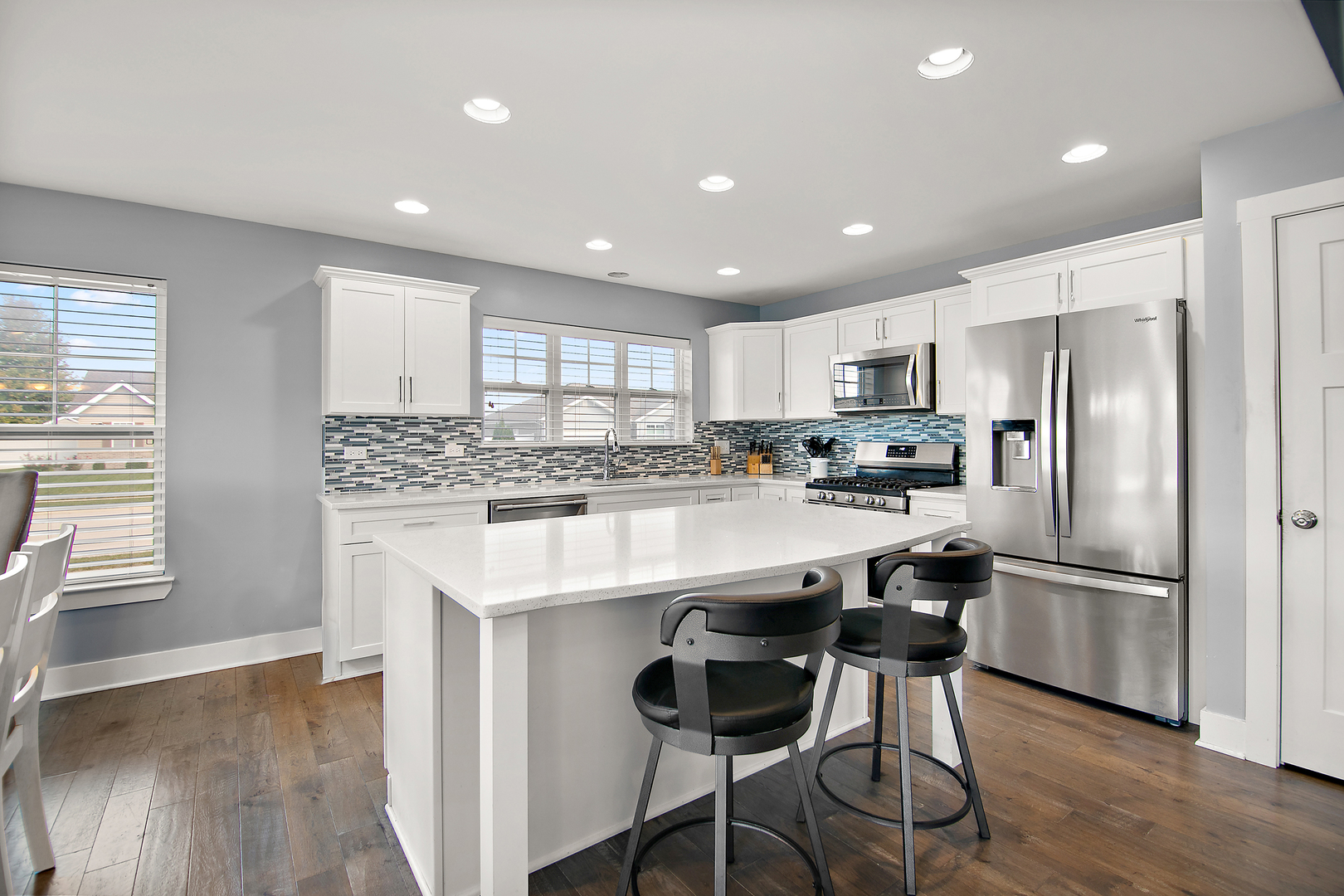 489 Cardinal Drive Manteno, IL 60950 - Photo 7 of 38 a kitchen with kitchen island white cabinets appliances and wooden floor