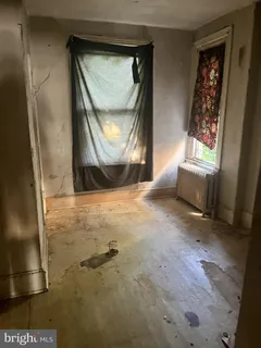 a view of a livingroom with wooden floor and a window