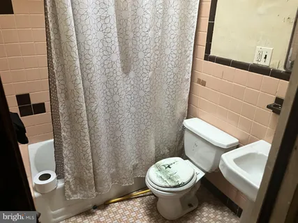a white toilet sitting next to a shower curtain