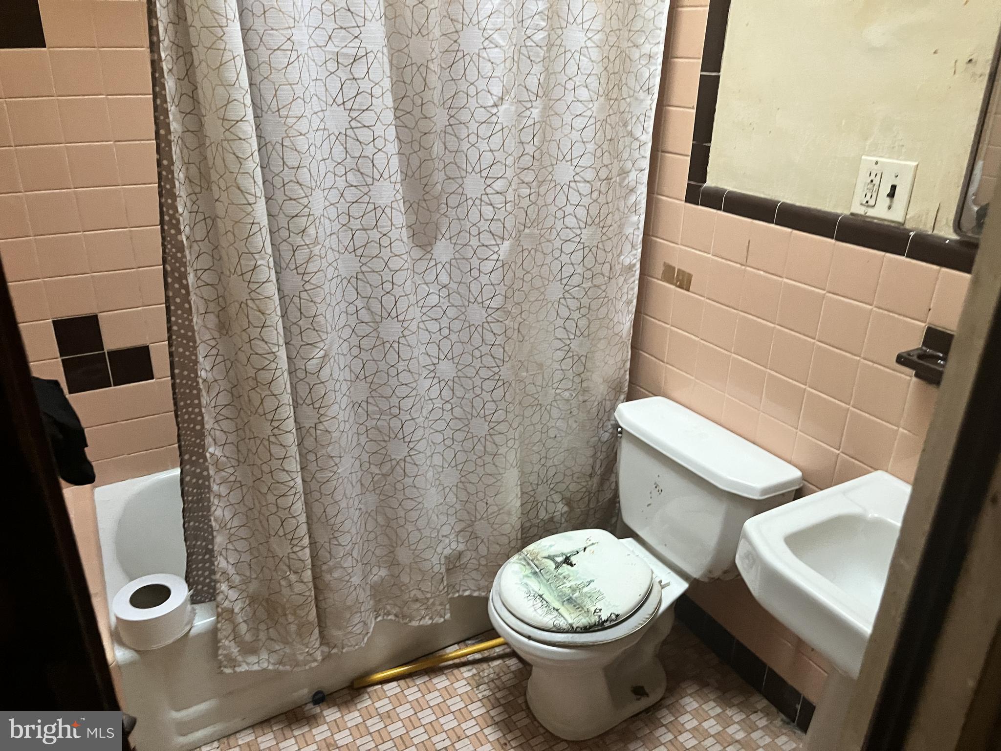 2736 North 24th Street Philadelphia, PA 19132 - Photo 4 of 14 a white toilet sitting next to a shower curtain