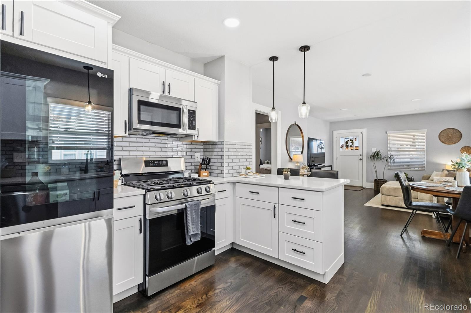 1620 Galena Street Aurora, CO 80010 - Photo 12 of 34 a kitchen with stainless steel appliances granite countertop a stove and white cabinets