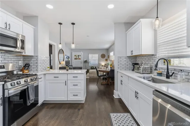 a kitchen with white cabinets and appliances