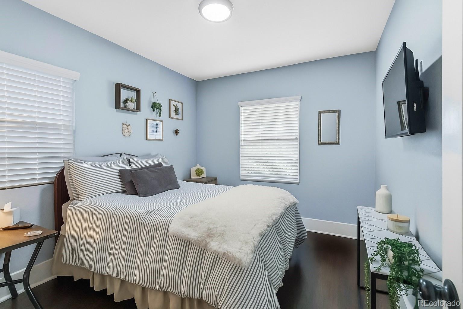 1620 Galena Street Aurora, CO 80010 - Photo 18 of 31 a bedroom with a bed and a flat screen tv