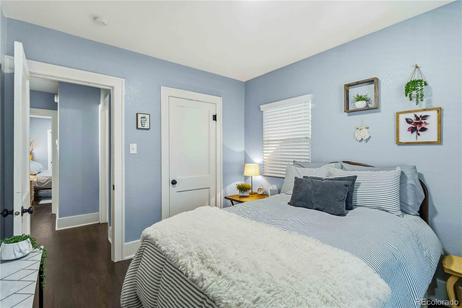 1620 Galena Street Aurora, CO 80010 - Photo 19 of 31 a bedroom with a bed and wooden floor