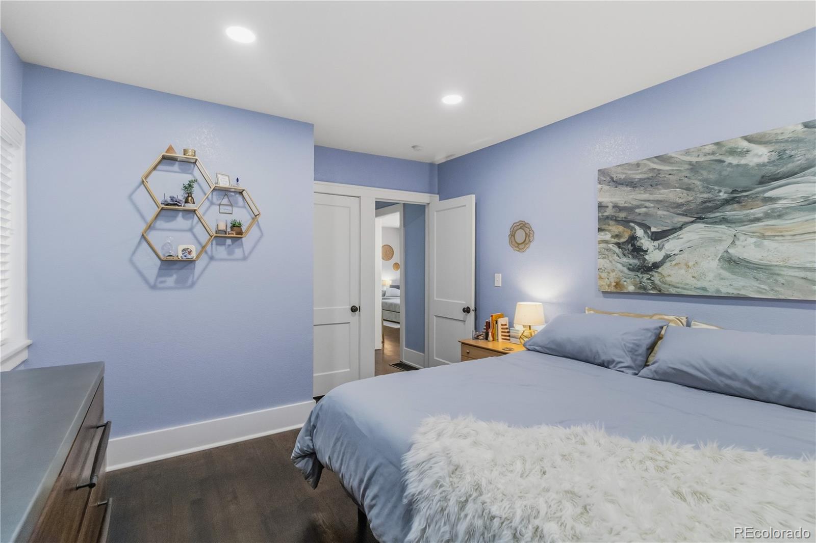 1620 Galena Street Aurora, CO 80010 - Photo 20 of 34 a bedroom with a bed and a chandelier