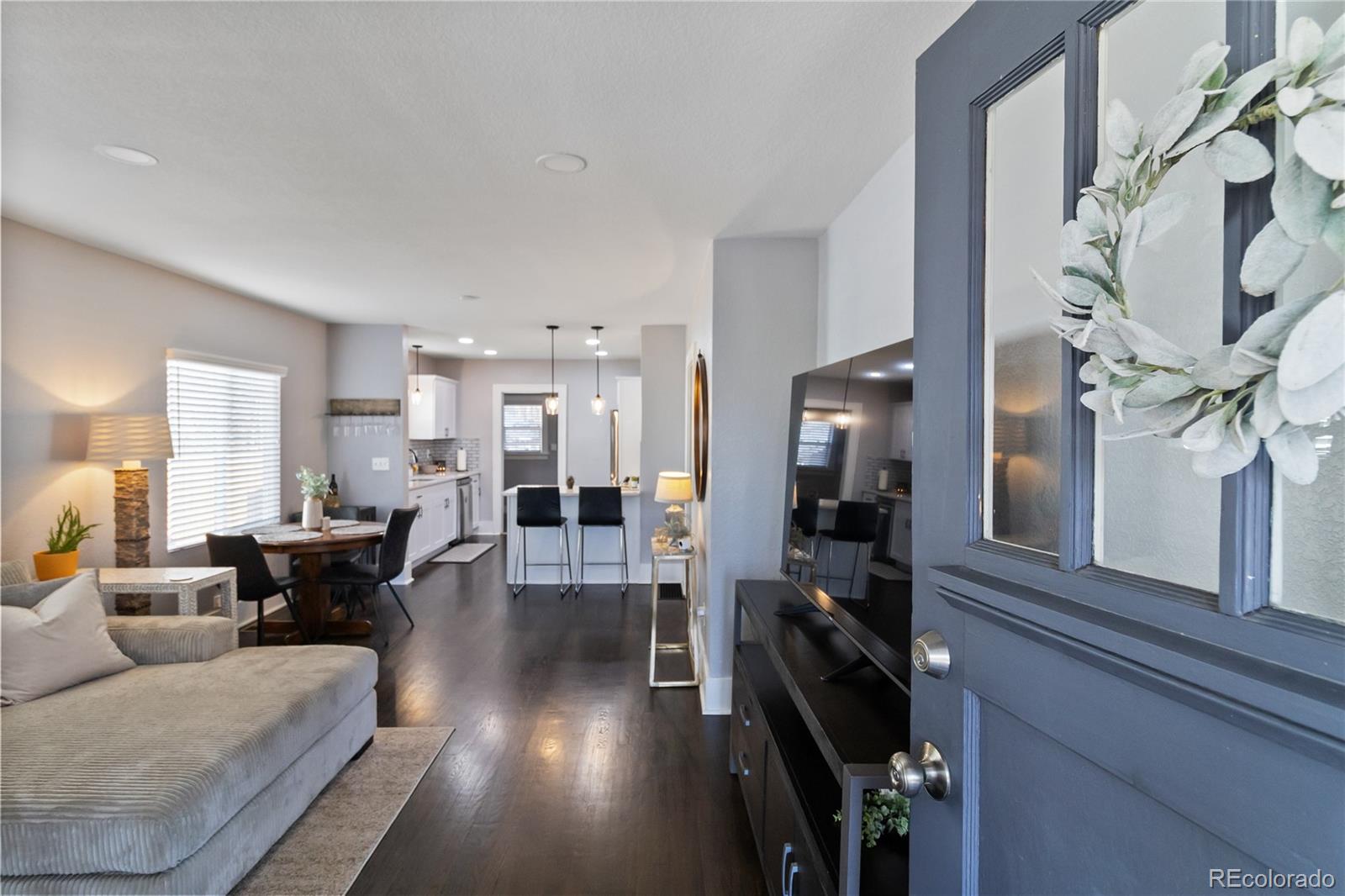 1620 Galena Street Aurora, CO 80010 - Photo 3 of 34 a living room with furniture and a chandelier
