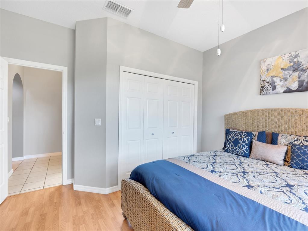 411 Ridge View Drive Davenport, FL 33837 - Photo 5 of 24 a bedroom with a large bed and wooden floor