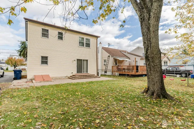 a white house that has a tree in front of it