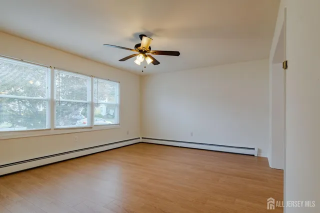 an empty room with a window and a ceiling fan