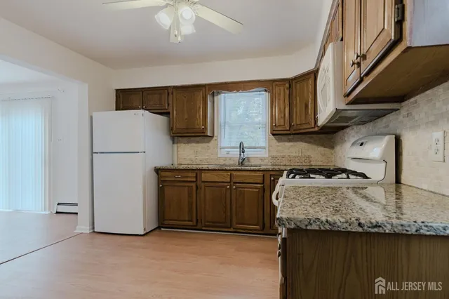 a kitchen with granite countertop a sink a counter space and cabinets