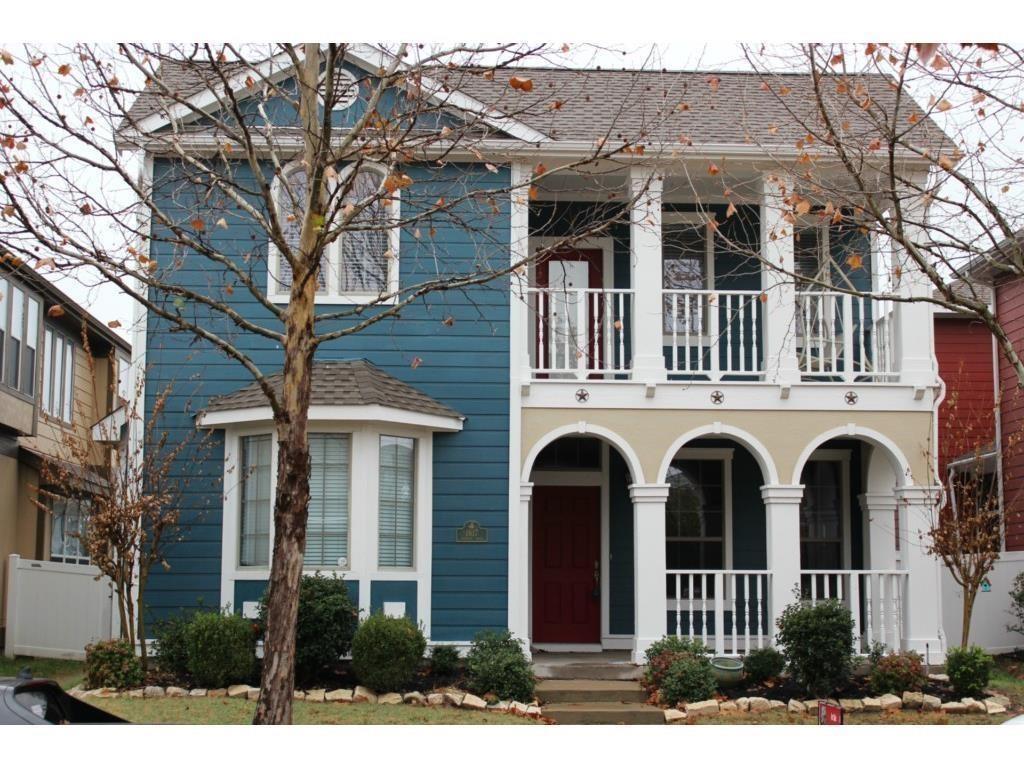 View of front of home with a balcony, covered porch, and roof with shingles