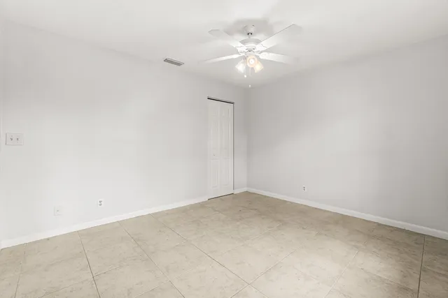 an empty room with a chandelier fan