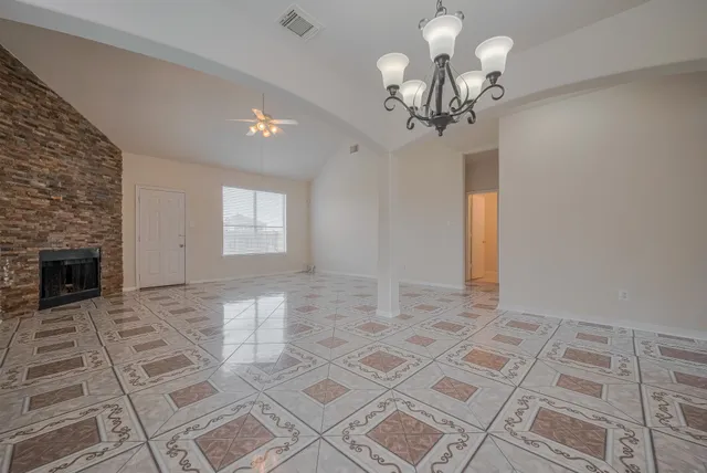 a view of a livingroom with a chandelier fan and windows