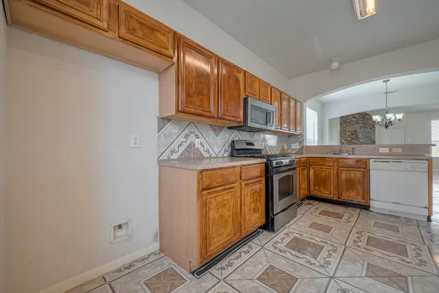 a kitchen with stainless steel appliances granite countertop a stove a sink and a refrigerator