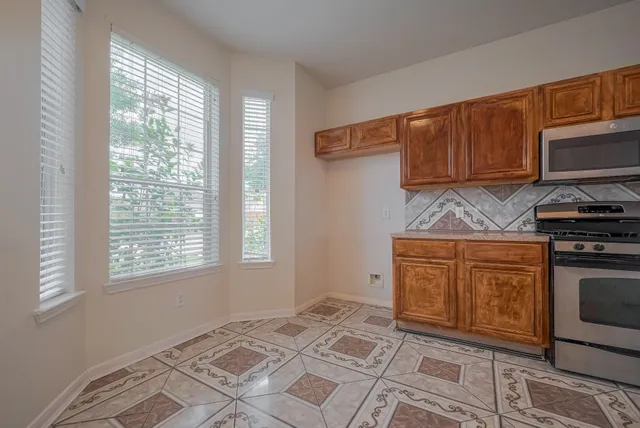 a kitchen with stainless steel appliances granite countertop a stove a sink and a microwave