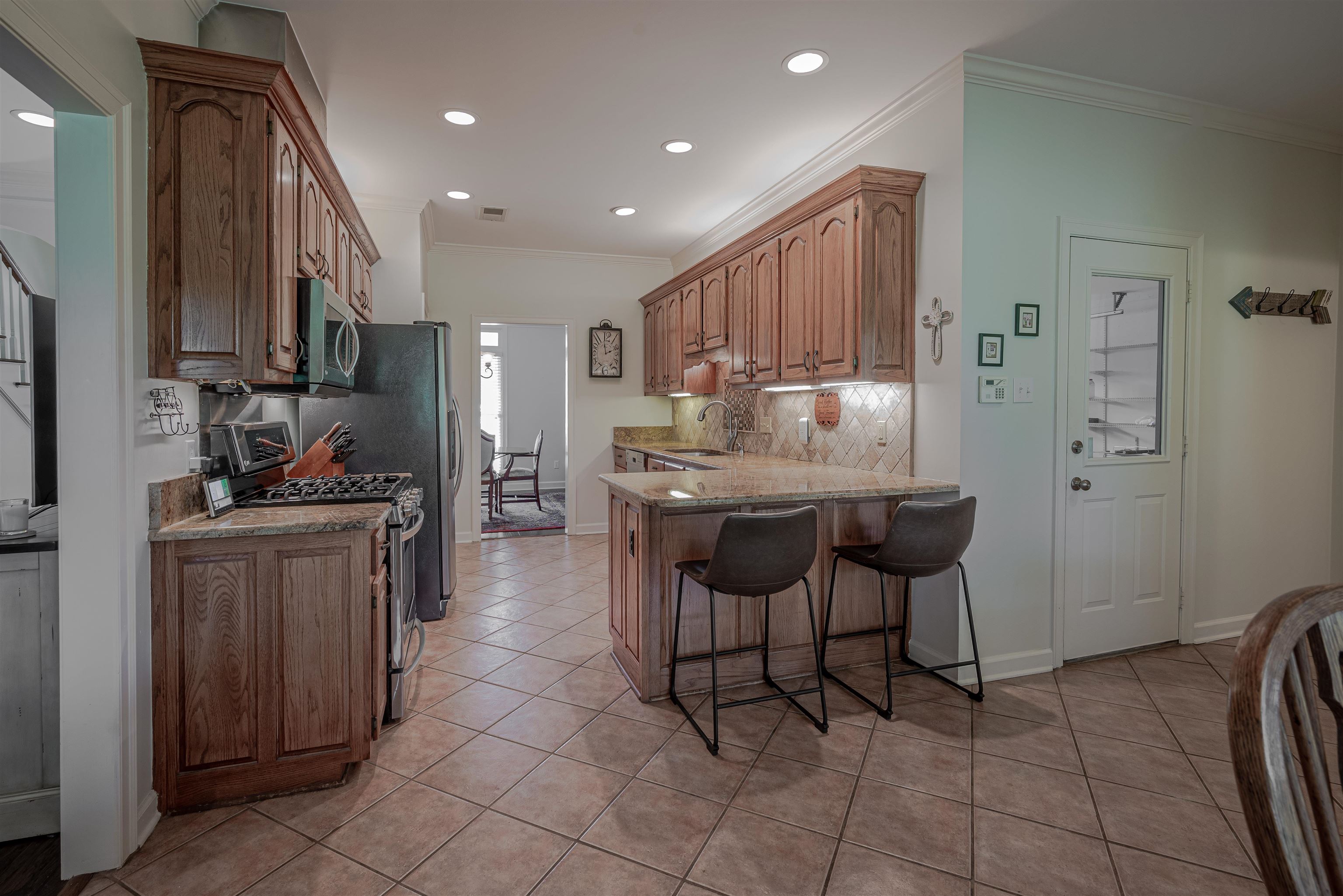 752 Gable Lane Collierville, TN 38017 - Photo 8 of 40 a kitchen with kitchen island granite countertop wooden cabinets a sink and appliances