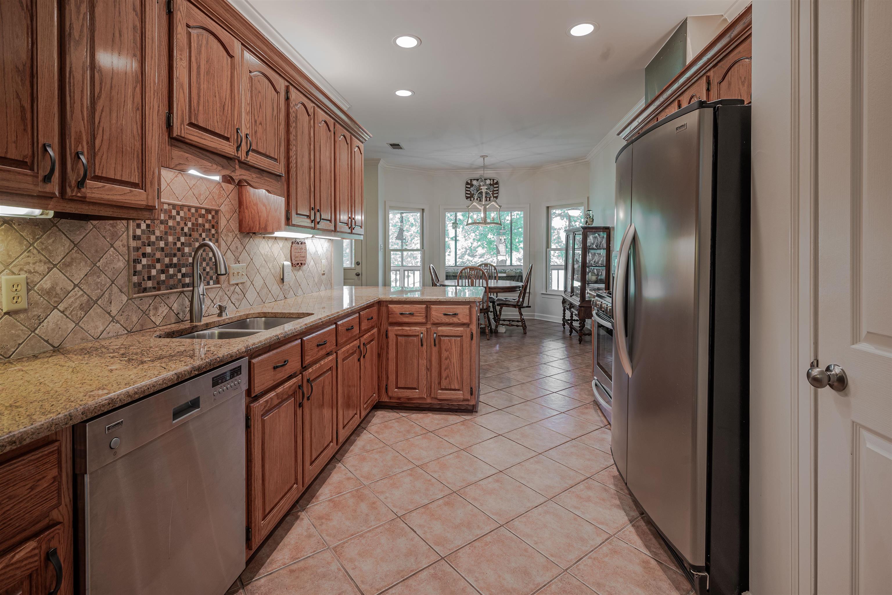 752 Gable Lane Collierville, TN 38017 - Photo 9 of 40 a kitchen with stainless steel appliances granite countertop a refrigerator a sink a stove and a wooden cabinets