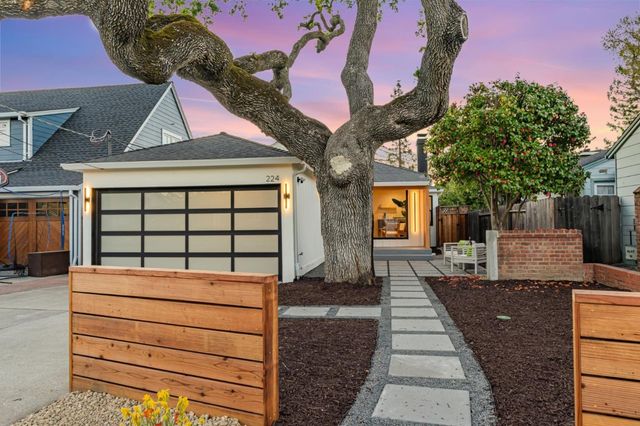 a view of a brick house with a large tree in front of it