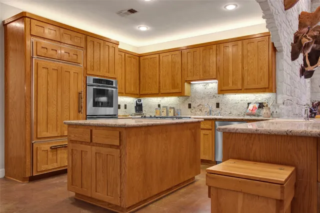 a living room with stainless steel appliances kitchen island granite countertop furniture and a kitchen view
