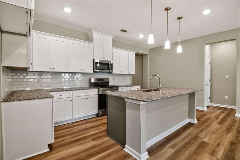 103 Gnome Court Perry, GA 31069 - Photo 15 of 30 a kitchen with kitchen island granite countertop a sink appliances and cabinets