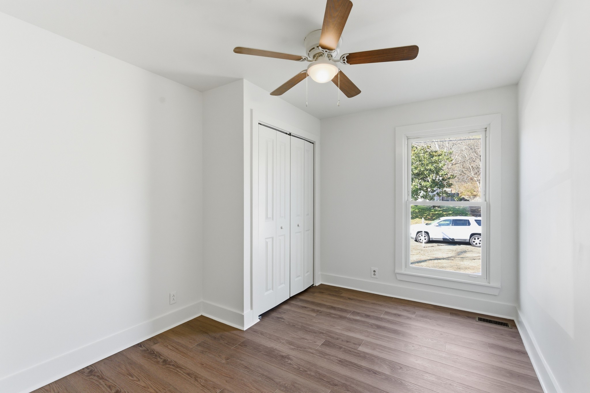 206 New Sawyer Brown Road Nashville, TN 37221 - Photo 18 of 46 an empty room with wooden floor fan and windows