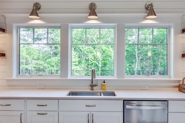 a large white kitchen with a large window