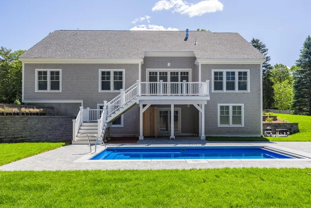a view of a house with a swimming pool and a yard