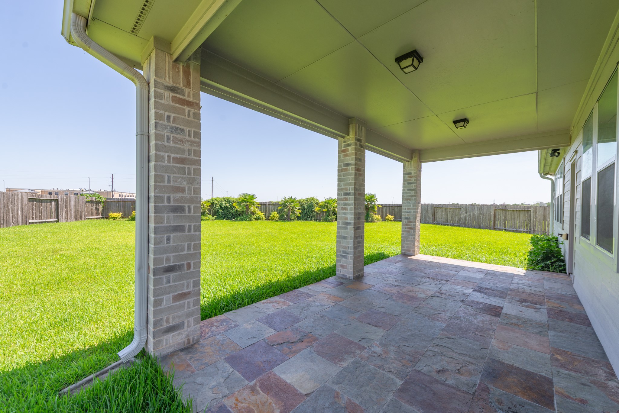 26302 Fox Ridge Lane Katy, TX 77494 - Photo 8 of 35 Spacious covered patio with elegant stone flooring, perfect for outdoor gatherings and relaxation.